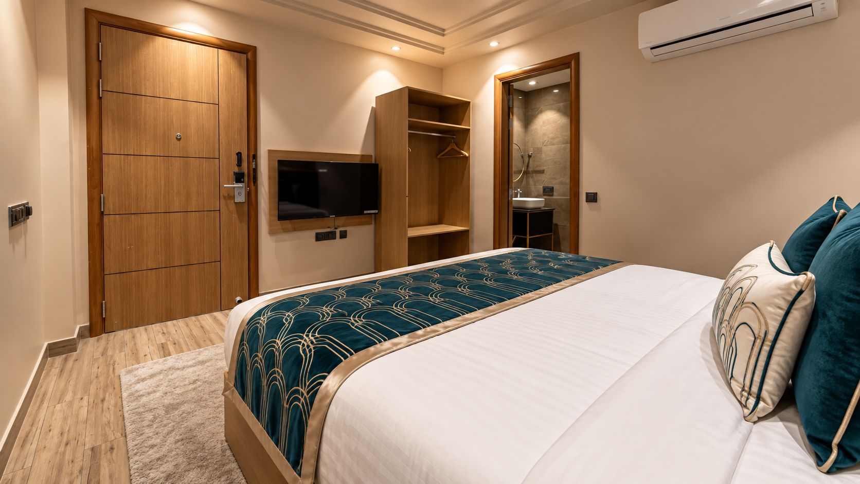 A hotel room with a bed, a TV, a wardrobe, and a bathroom.