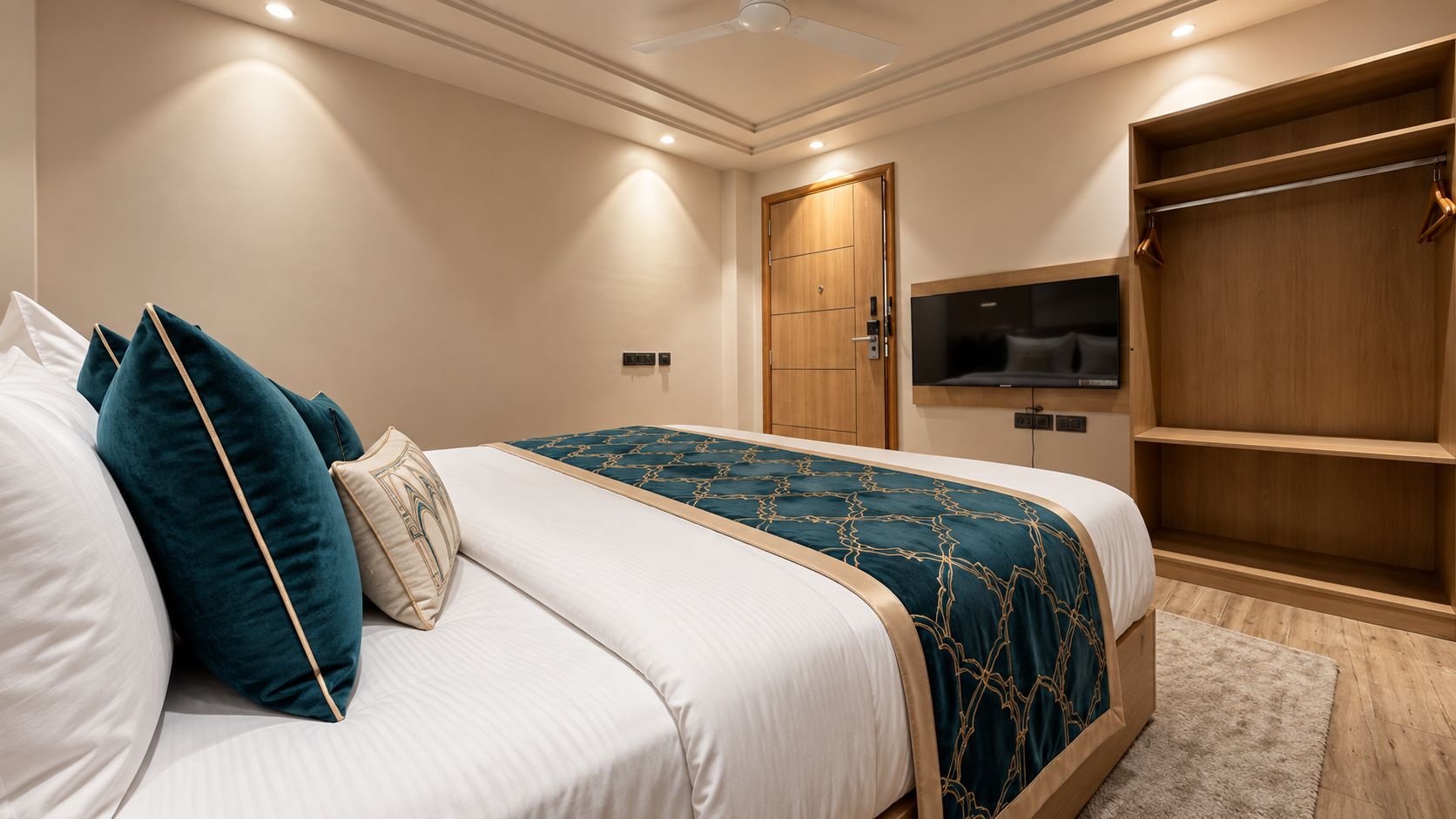 A hotel room with a bed, a television, a wardrobe, and a door.