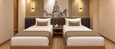 Habitación de hotel con dos camas, una mesita de noche con lámpara y una obra de arte en la pared de una famosa torre.