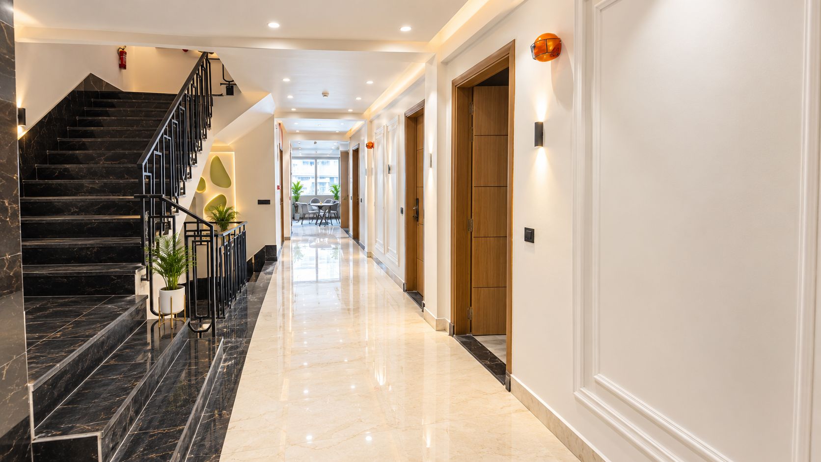 A hotel hallway with a marble staircase, a flat floor, and a view into the dining area.