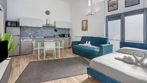 Un appartement moderne comprenant une cuisine, un coin repas et une chambre.