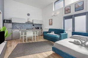 Un appartamento moderno con cucina, zona pranzo e camera da letto.