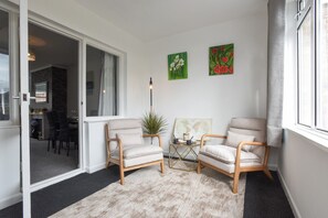 A corner room with two armchairs, a small table with a world map, and a plant. - Spacious Portchester Home with Garden & Parking (Portchester)