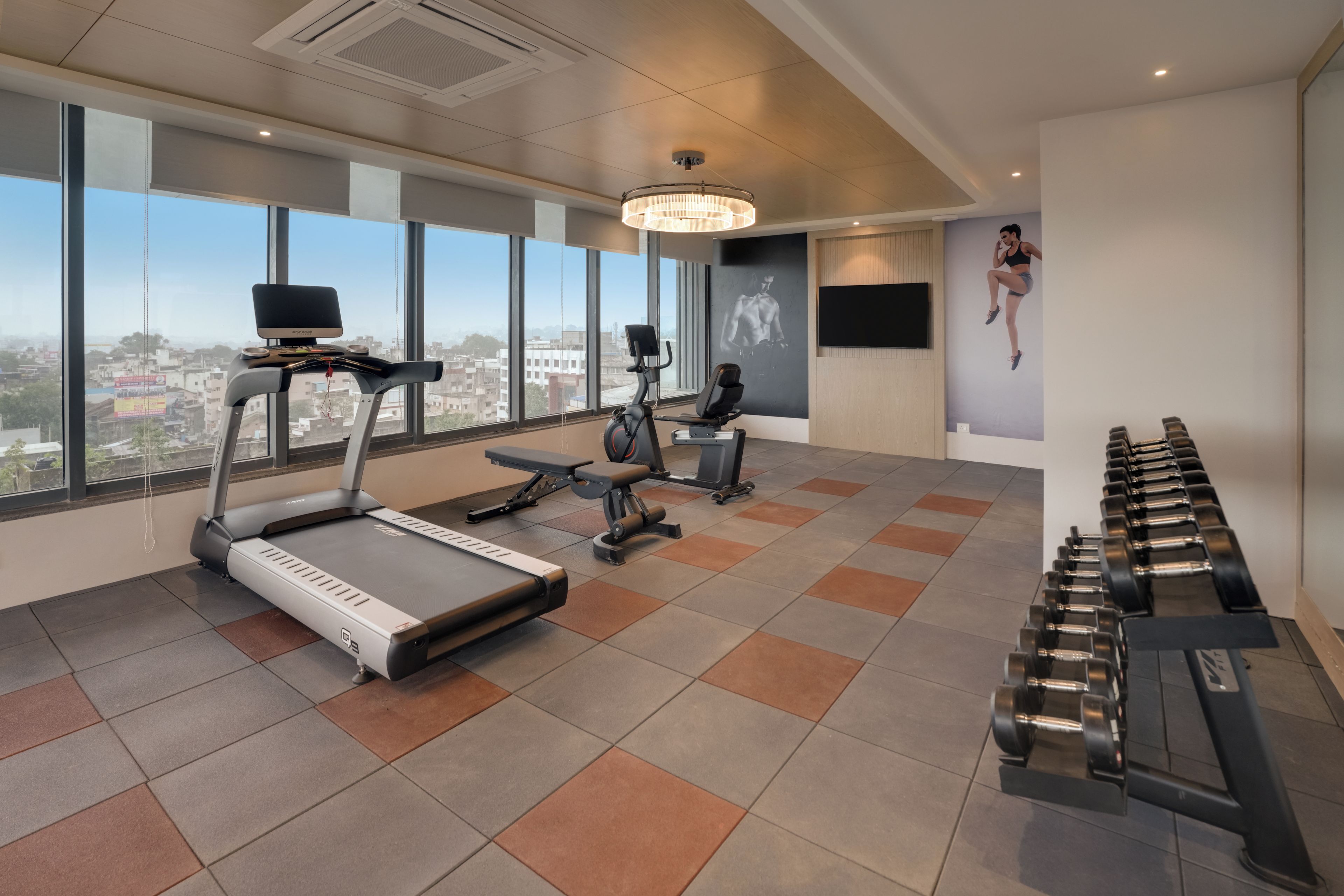 A gym with treadmills, a stationary bike, and dumbbells.