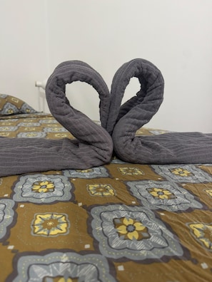 A bed with a patterned bedspread and a towel arranged in a heart shape. - Peaceful 4-bedroom apartment in welcoming Toulouse neighborhood (Toulouse)