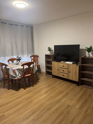 A dining area with a table, chairs, a television on a wooden cabinet, and a potted plant. - Peaceful 4-bedroom apartment in welcoming Toulouse neighborhood (Toulouse)