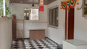 A room with a checkered floor, a ceiling fan, a window, and a door.