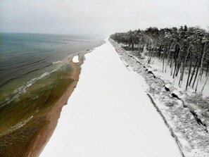 A snow-covered beach with a clear path leading to the water. - Osada Rybacka - Seaside Cottage, Sauna included (Powiat wejherowski)