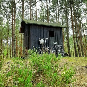 A rustic wooden cabin with a bicycle parked in front. - Osada Rybacka - Forest Cottage, Sauna included (Powiat wejherowski)