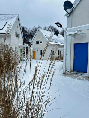 A residential area with houses, a blue door, and satellite dishes. - Osada Rybacka - Forest Cottage, Sauna included (Powiat wejherowski)