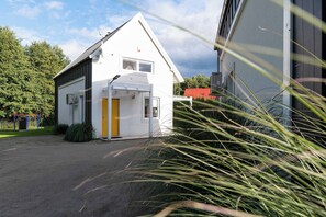 Ein Gebäude mit weißer Fassade, gelber Tür und rotem Dach.