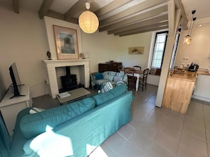 A living room with a sofa, a fireplace, a dining area, and a kitchen.