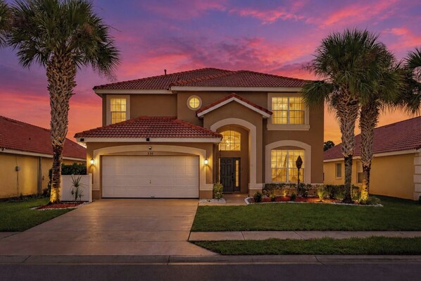 Ein zweistöckiges Haus mit Garage, Auffahrt und gepflegtem Rasen.