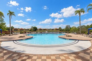A swimming pool with a tiled deck, surrounded by lounge chairs and palm trees. - 6BR Aviana Resort Escape | Pool, Spa + Game Room (Davenport)