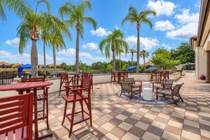 A patio area with outdoor seating and palm trees. - 6BR Aviana Resort Escape | Pool, Spa + Game Room (Davenport)