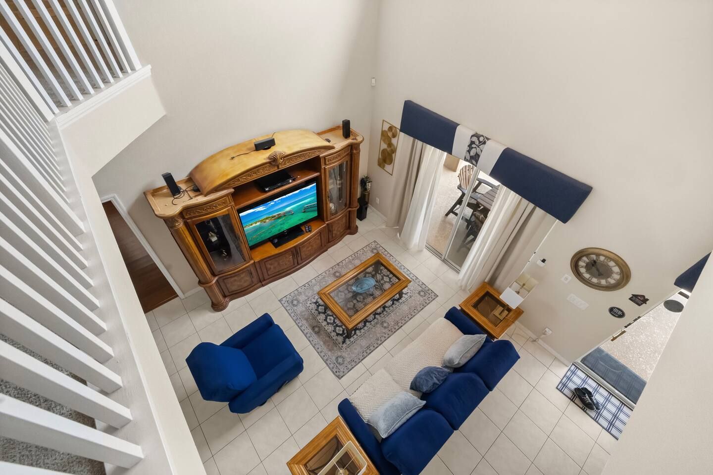 Una sala de estar con televisor, dos sofás, una mesa de centro y un tapete estampado.