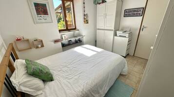 Une chambre à coucher avec un lit, une armoire, un bureau et une fenêtre.