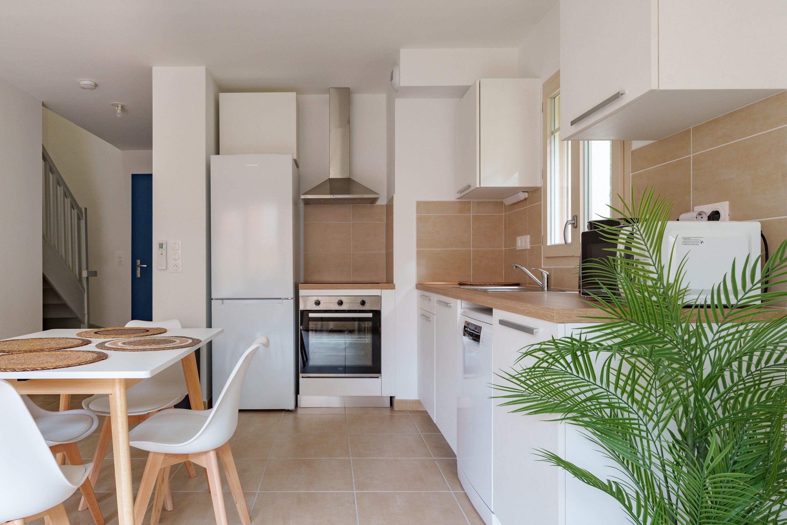 Una cocina compacta con horno empotrado, lavavajillas y refrigerador.