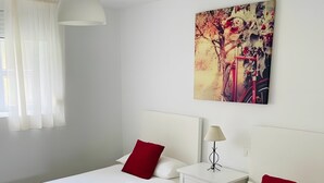 Ein Hotelzimmer mit zwei Betten, einem Nachttisch, einer Lampe und einem Bild an der Wand.