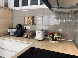 A modern kitchen with a coffee maker, toaster, and jars on the counter.