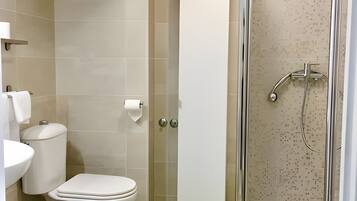 Un baño con inodoro, lavamanos y ducha.