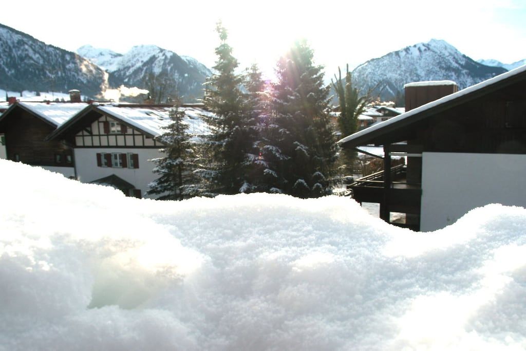 A snowy mountain landscape with buildings and trees.