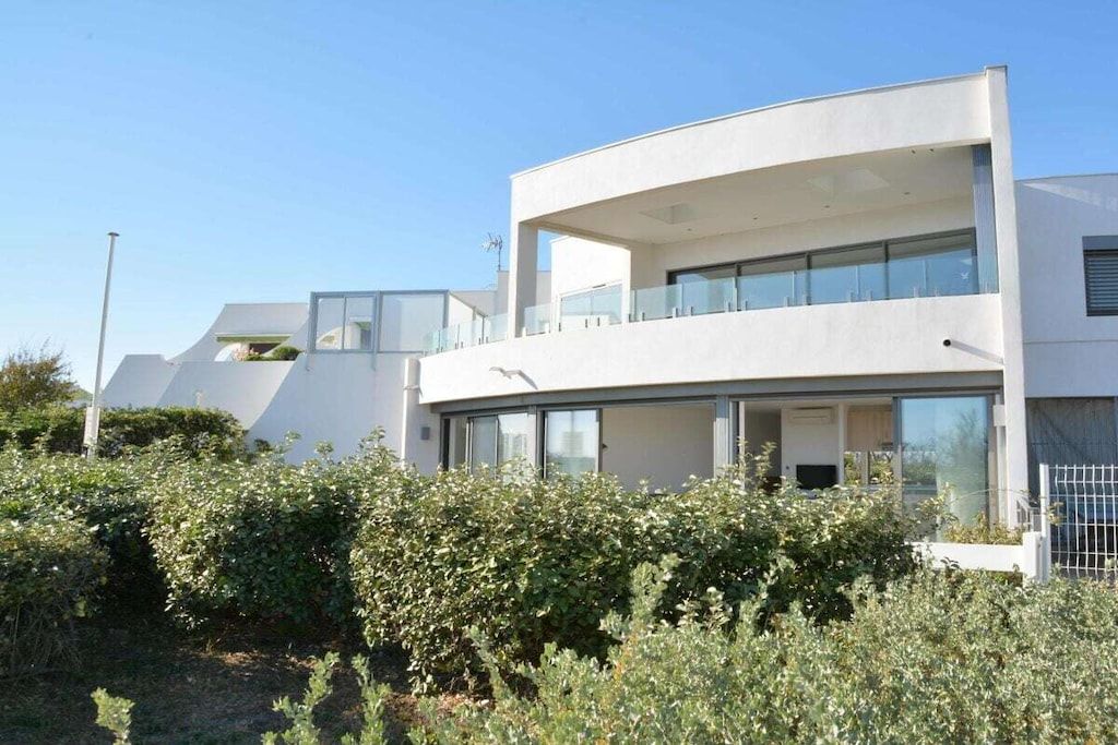 A modern two-story building with large windows and a balcony.