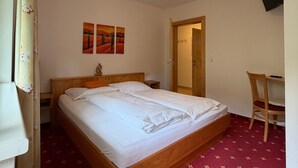 A bedroom with a bed, a desk, a chair, and a television on the wall. - Apartment Markus: Gartenwohnung mit Bergblick, privatem Garten, WLAN & Spa (gegen Aufpreis) (Ried im Zillertal)