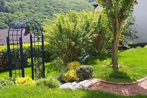 A garden with a pergola, various shrubs, and a tree. - Holiday apartment with 1 bedroom (Klotten)