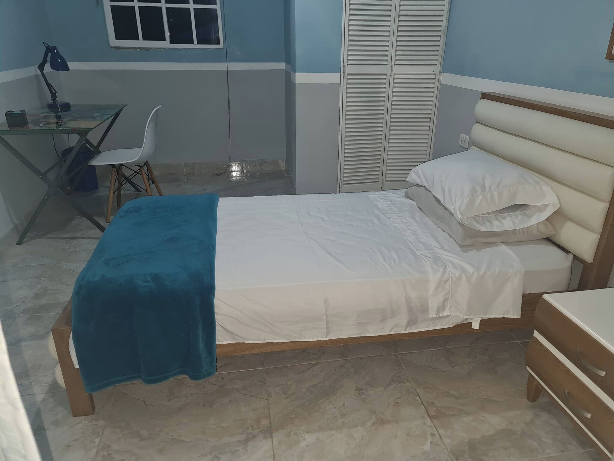 Une chambre à coucher avec un lit, un bureau et une chaise.