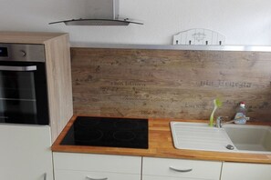 A kitchen with a built-in oven, a stovetop, and a sink. - Imperial on the Eifelsteig (Gerolstein)