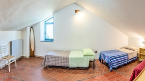 A dormitory room with two beds, a chair, a small table, and a window. - The Hedgehog Trail (Sicignano degli Alburni)