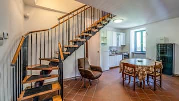 Una cucina moderna con una scala a chiocciola, un'area pranzo con un tavolo rotondo e una sedia.