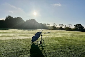 A golf cart on a grassy field with a clear sky and sunlight. - Holiday apartment in Travemünde with Wi-Fi (Travemünde)