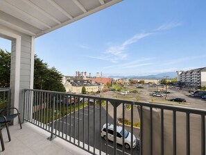 Ein Balkon mit Blick auf einen Parkplatz und Gebäude.