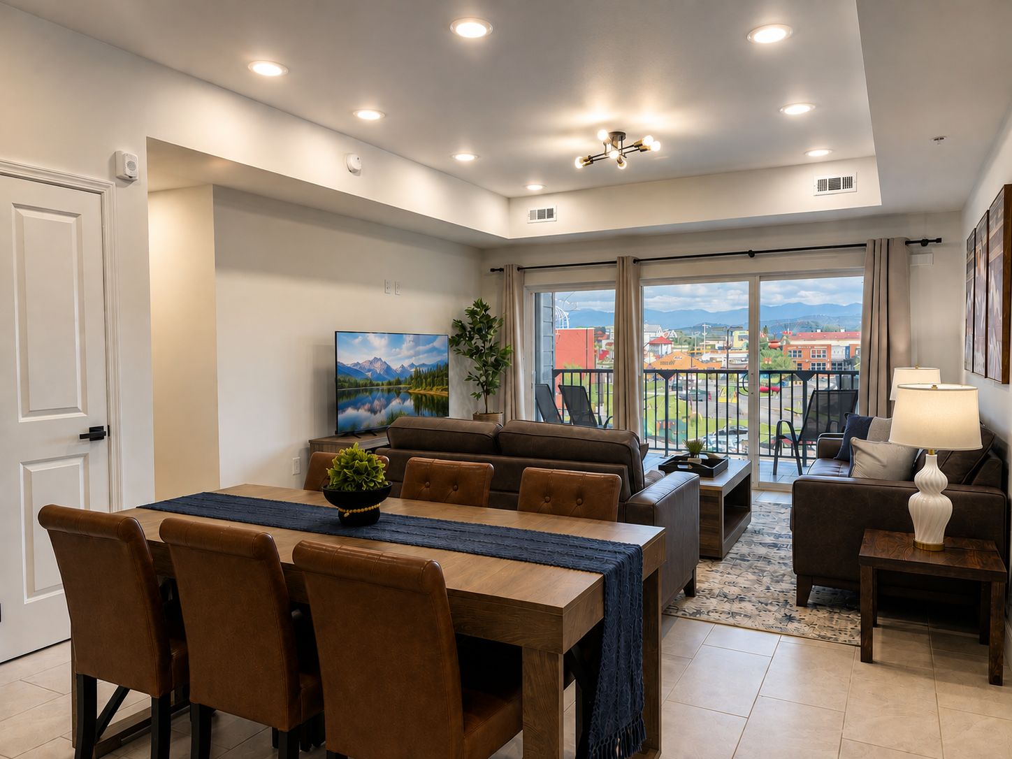 Un soggiorno moderno con zona pranzo, divano, televisione e balcone con vista.
