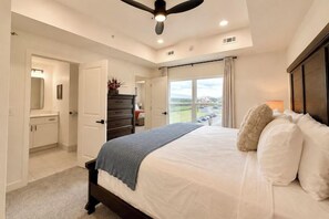 Ein Schlafzimmer mit Bett, Kommode und Blick ins Freie.