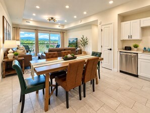 A modern dining area with a wooden table, leather chairs, and a view of the outdoors. - New Pigeon Forge Condo | Mt View (Pigeon Forge)