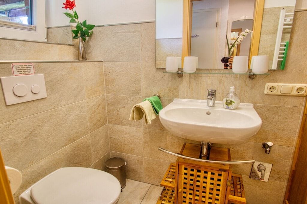 Ein Badezimmer mit Waschbecken, Spiegel, Toilette und Mülleimer.