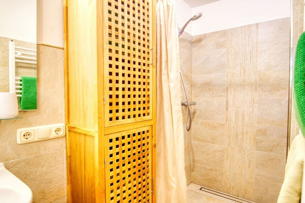 Ducha con puerta de madera y cabina de cristal.