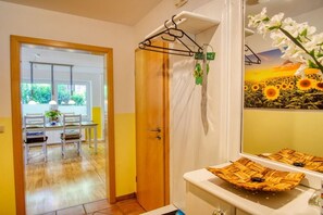 A bathroom with a shower, a mirror, and a sink with a woven basket. - Holiday apartment with 2 bedrooms (Amelinghausen)