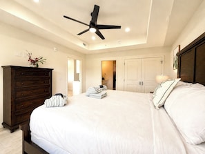 A bedroom with a large bed, a ceiling fan, a dresser, and a nightstand. - New Pige Forge Condo | Steps to Parkway (Pigeon Forge)
