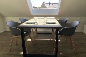Ein Essbereich mit einem Tisch für vier Personen, vier Stühlen und einem Oberlicht.