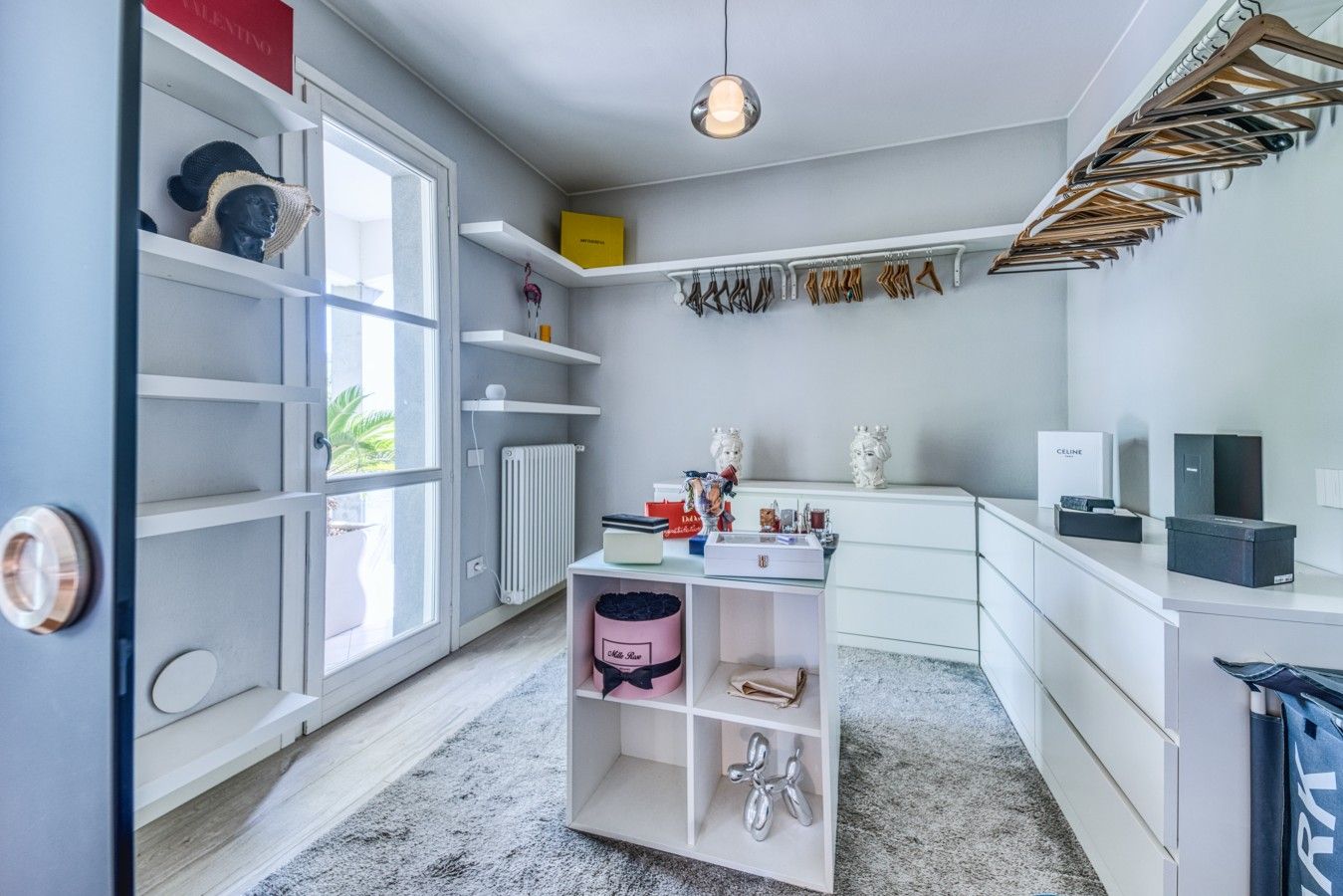 Une chambre moderne dotée d’une armoire intégrée, d’un radiateur, d’une étagère à chapeaux et d’un porte-vêtements suspendu.