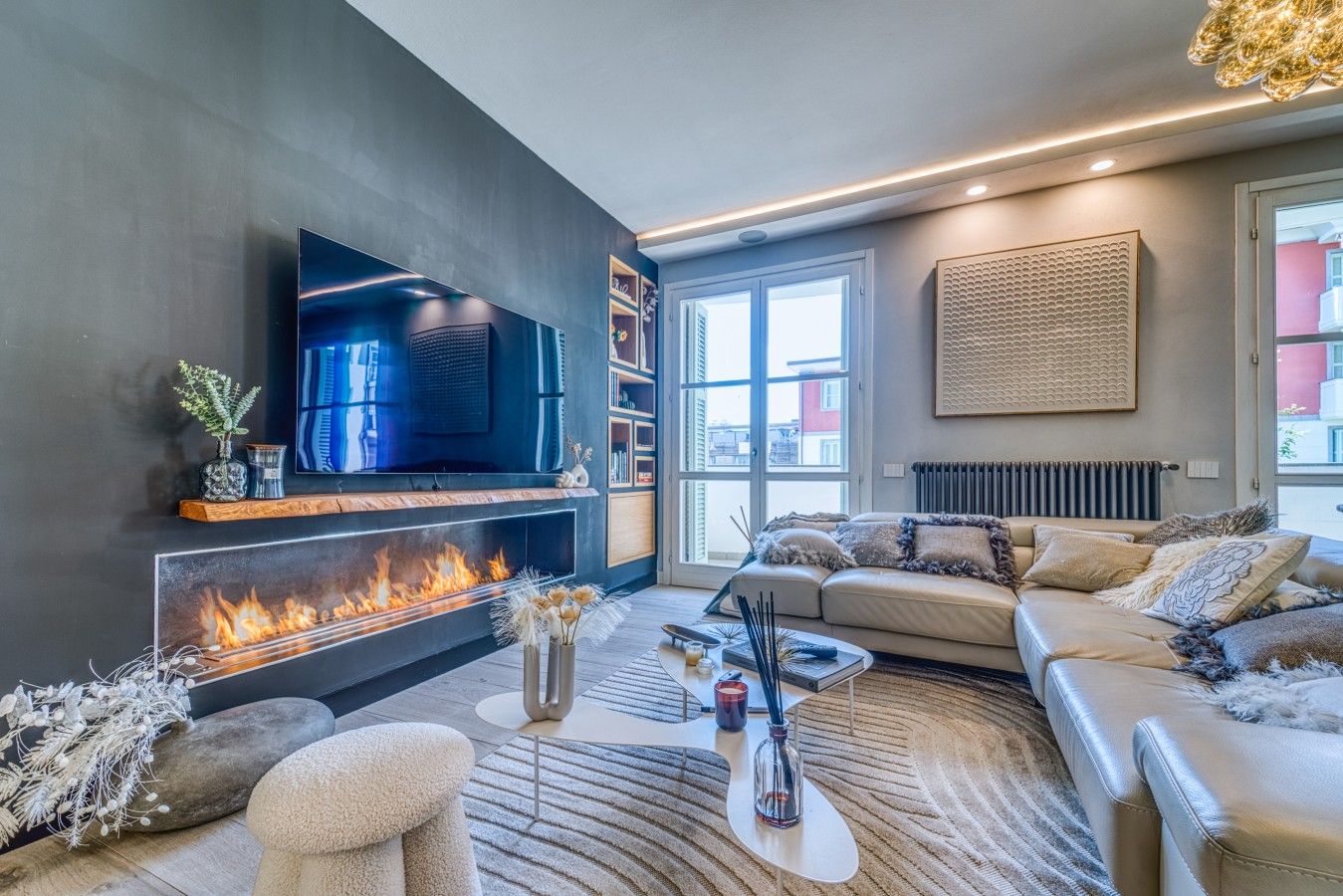 Ein modernes Wohnzimmer mit Kamin, einer Couch, einem Couchtisch und einem Fernseher.