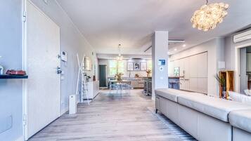 Un interior modern amb cuina, zona de dinar i saló amb sofà.
