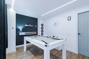 A billiards table with balls and cues, a clock on the wall, and a door to the right. - Stylish Home for 8 | Games Room & Free Parking (Northwich)