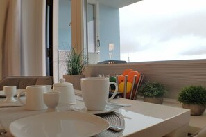 Ein Essbereich mit einem für das Frühstück gedeckten Tisch, einschließlich Tellern, Tassen und einem Teekessel.