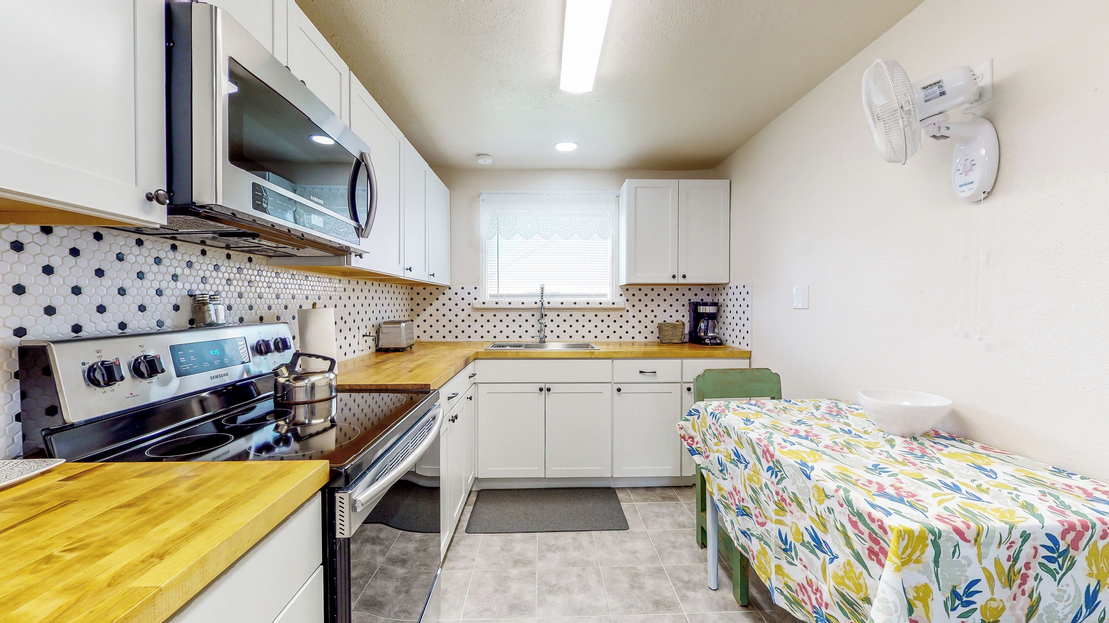 A compact kitchen with a microwave, stove, and toaster.