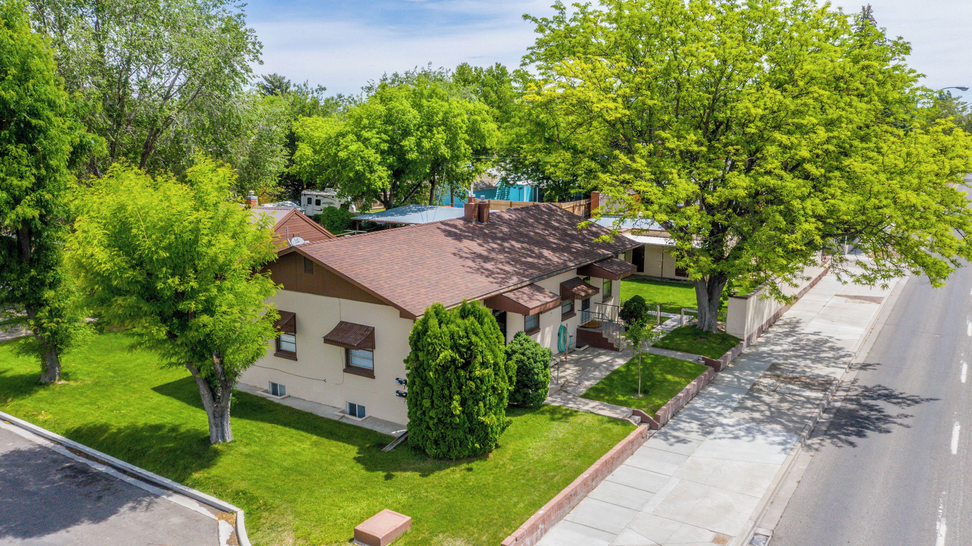 A residential property with a two-story house, a well-maintained lawn, and a driveway.